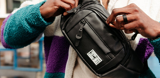 Man holding crossbody bag and unzipping smell proof carbon lined pocket