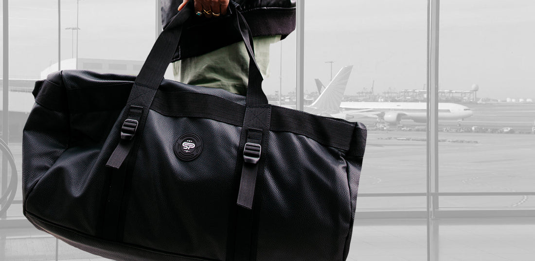 Person standing in airport with large L100 Transporter Faux Leather Duffel Bag