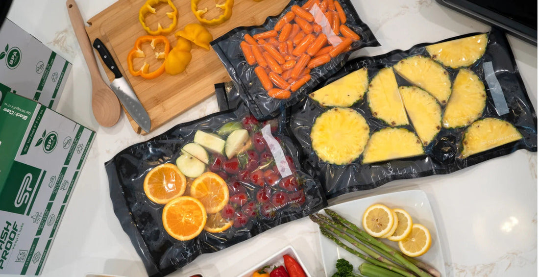 Black-and-clear Stash Proof vacuum-seal bags containing assorted fruits and vegetables on a kitchen counter.