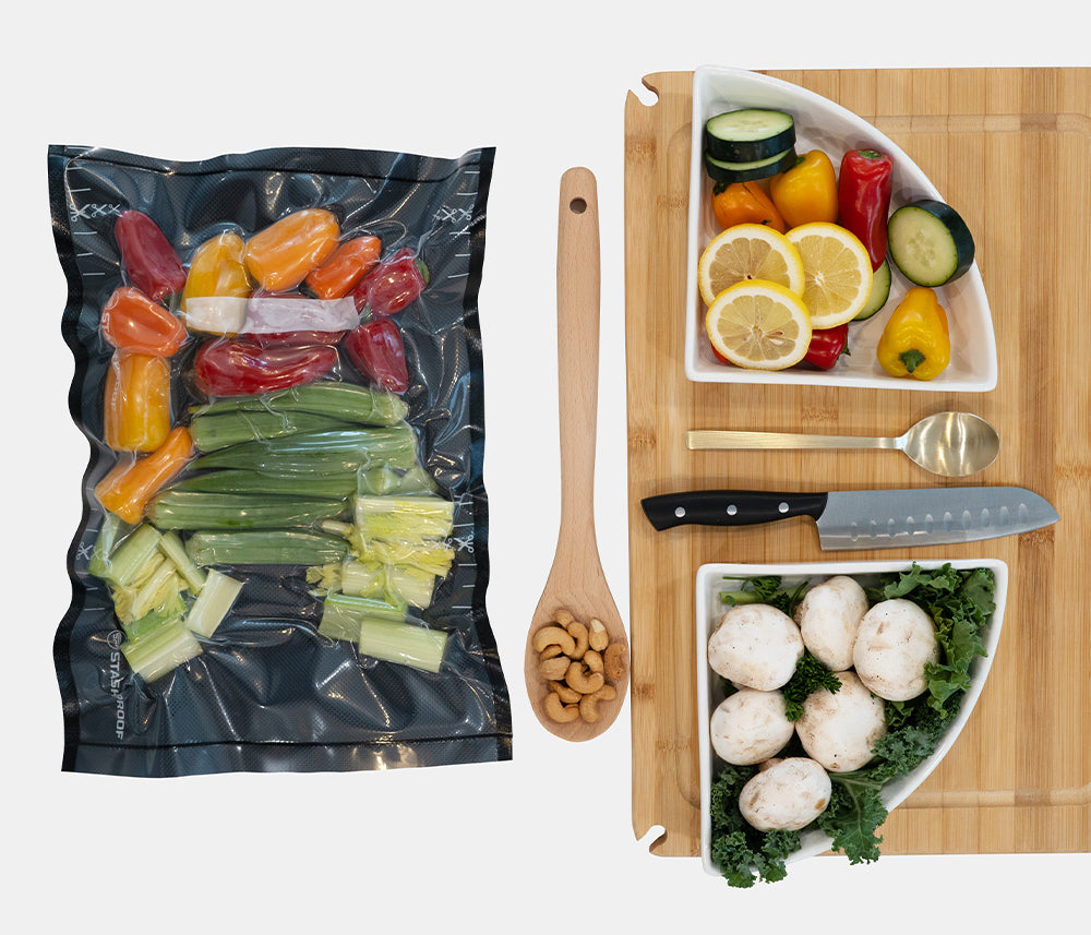 Vacuum-sealed bag of cut vegetables next to a cutting board with chopped vegetables and kitchen tools.