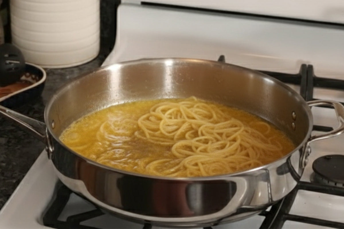 Spaghetti cooking in a pan on a stove