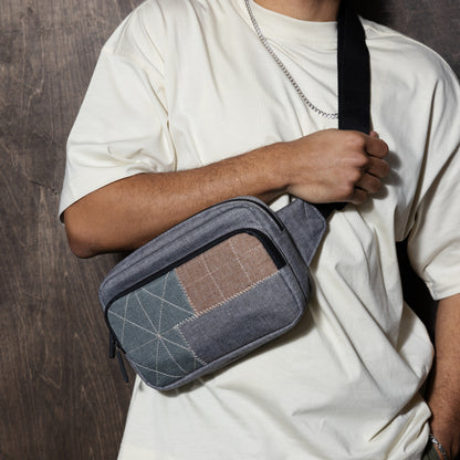carrying a gray earth tone crossbody bag with patchwork design and a off white shirt